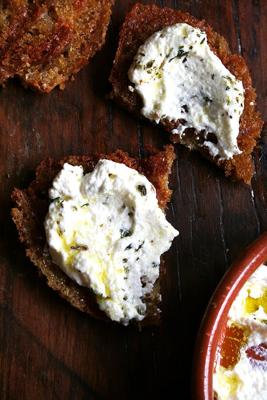 Slices of grilled bread topped with whipped ricotta and herbs.