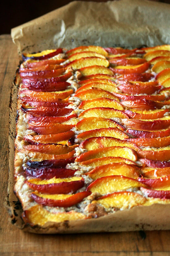 For this peach frangipane tart, my favorite galette dough is used for a sheet-pan tart. After smearing the whole batch of frangipane over its surface and arranging half a dozen sliced peaches over top, the fruit is brushed with melted butter and sprinkled with sugar. Forty minutes later, the tart emerges from the oven, slices of fruit glistening, frangipane bubbling through the crevices. // alexandracooks.com