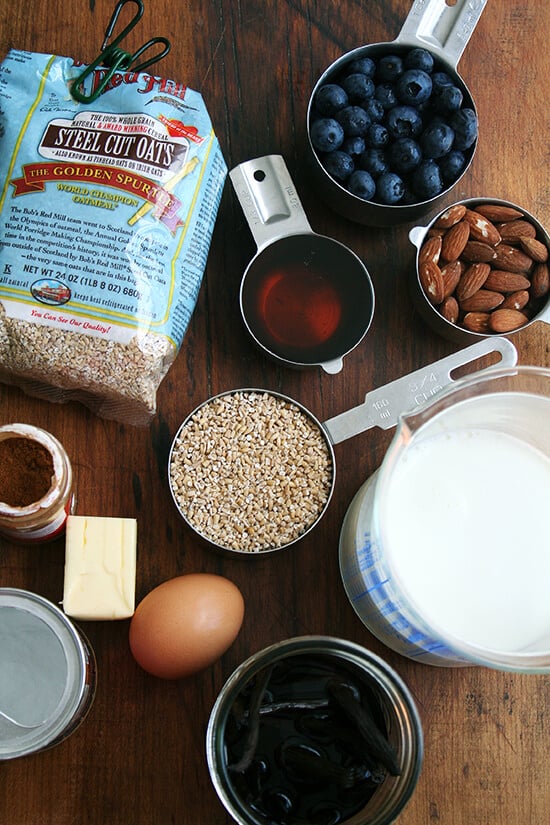 The ingredients for baked steel cut oatmeal: steel cut oats, maple syrup, butter, egg, vanilla, cinnamon, baking powder, milk, almonds and berries if you wish. 