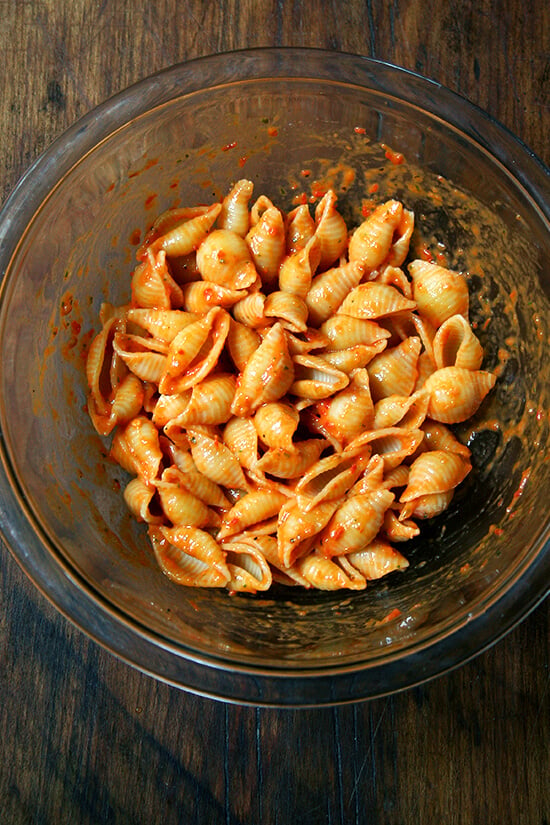 tossing the shells with the red bell pepper-tomato sauce