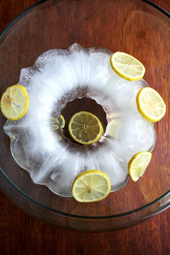 A punch bowl fitted with the ice ring and sliced lemon.