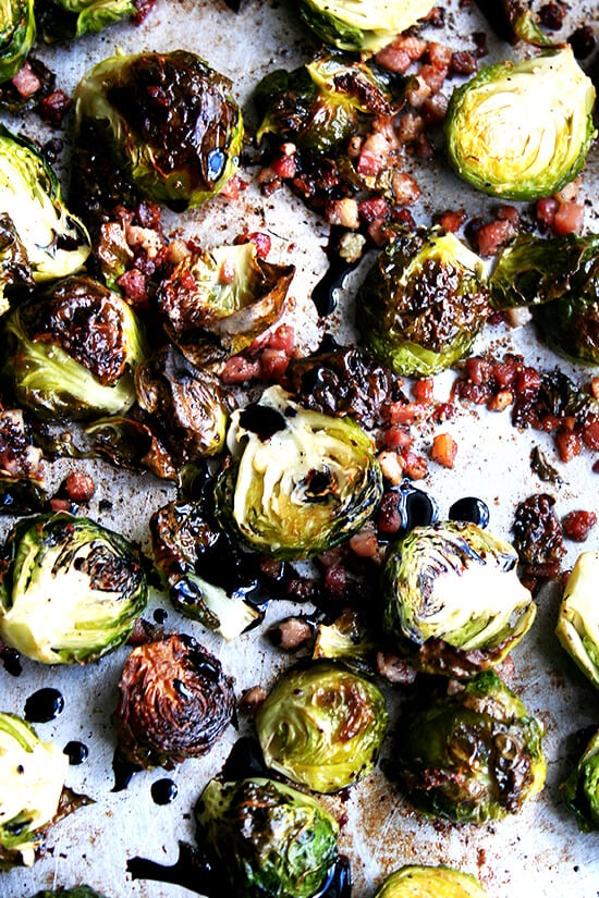 Close-up view of adding the balsamic reduction to the brussel sprouts in a sauce pan.