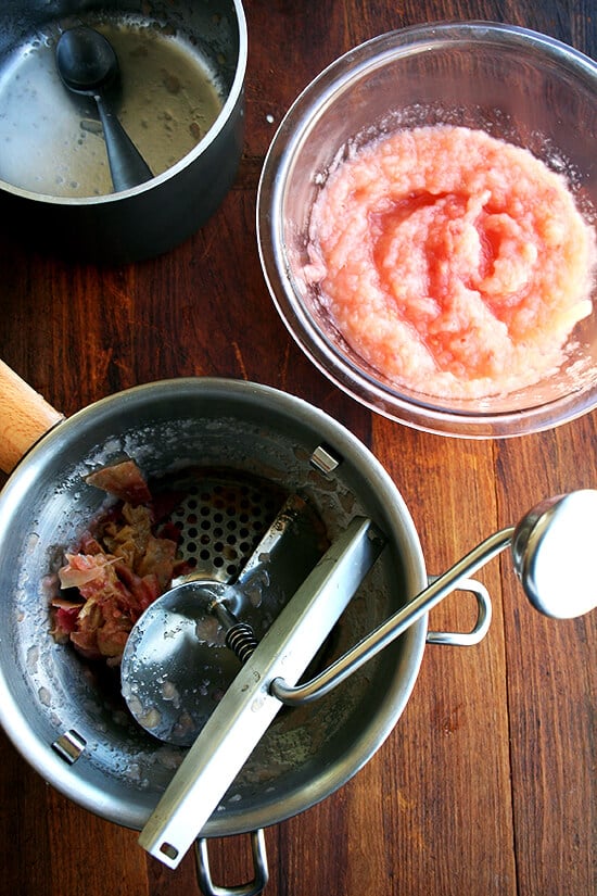 Food mill with crushed apples in it aside homemade applesauce.