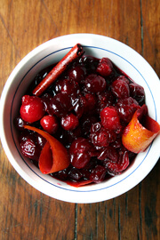 An overhead shot of a bowl of red wine cranberry sauce with cinnamon and orange zest.