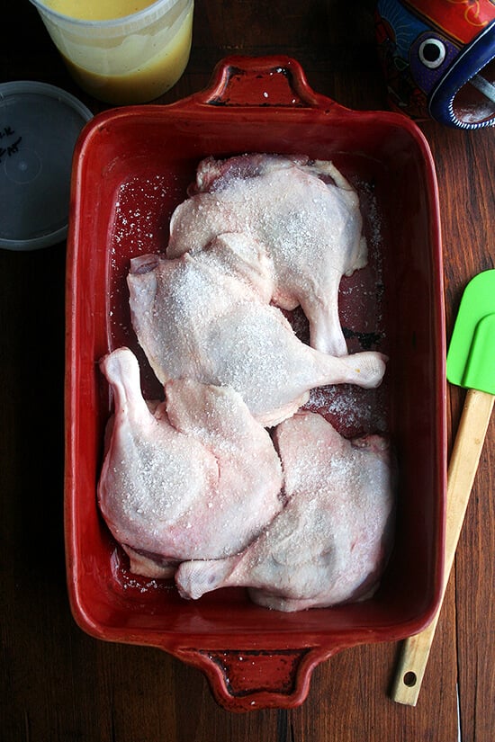 A 9x13-inch baking dish filled with 4 duck legs and salt.
