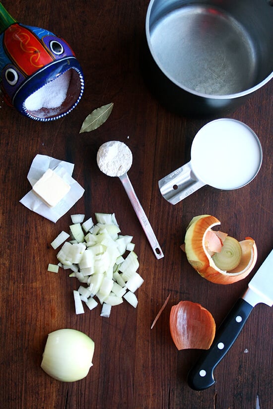 bechamel ingredients on a boardL onion, butter, flour, salt, milk, bay leaf.