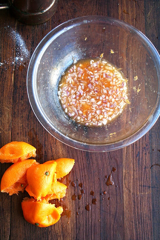 A bowl of shallots macerating in fresh clementine juice. 