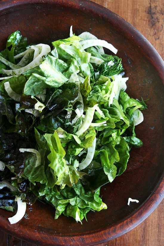 A bowl of salad tossed with a clementine dressing. 