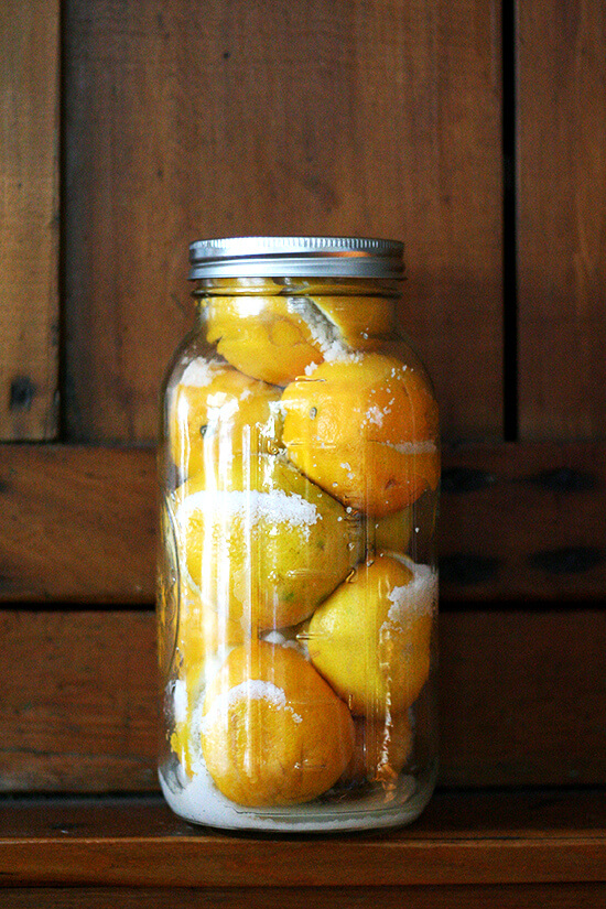 A jar of preserved lemons standing on a shelf.