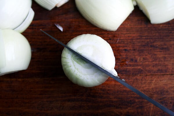 An onion with a knife inserted halfway down.