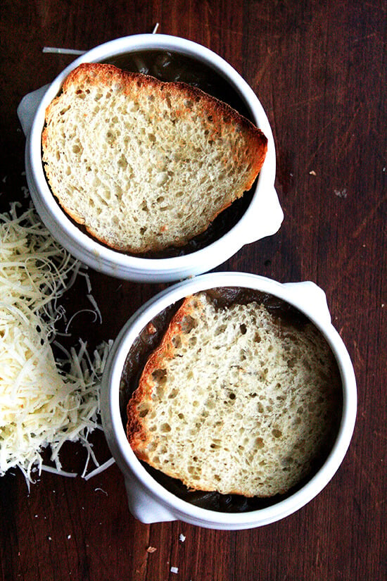 Two bowls of French Onion soup topped with toasted bread.