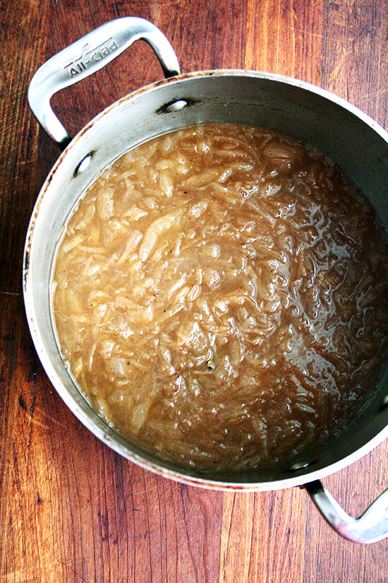 An overhead shot of a large pot of French Onion Soup.