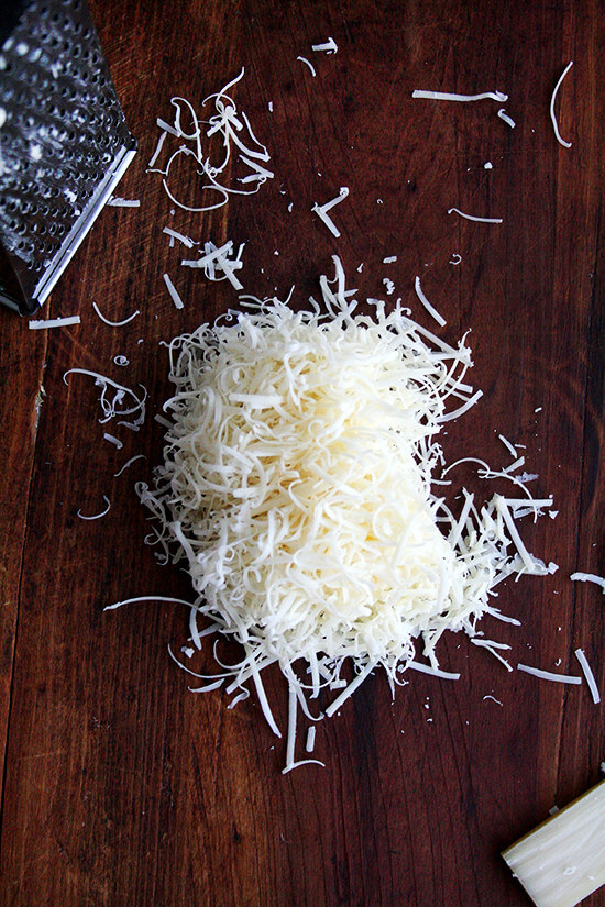 Grated Gruyère cheese on a board.