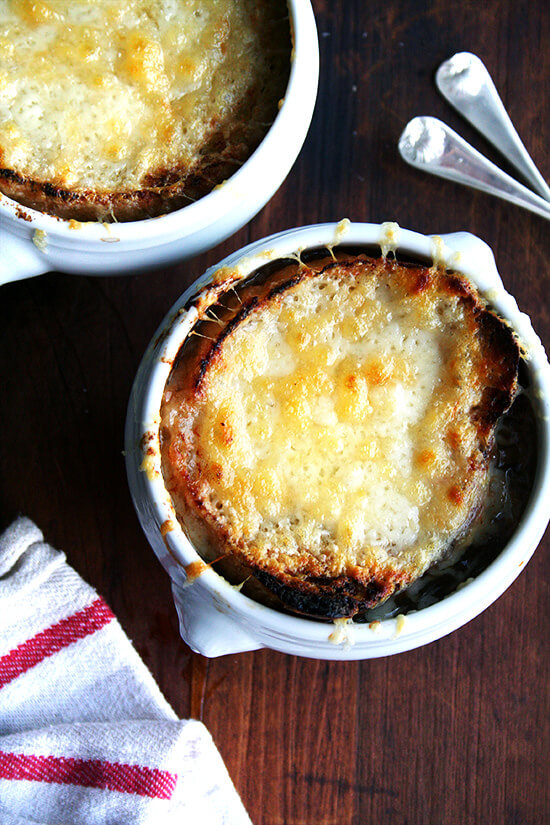 An overhead shot of two bowls of classic French onion soup.