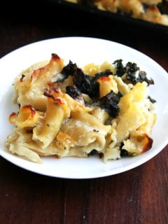 A portion of sheet pan pasta gratin with kale on a plate.