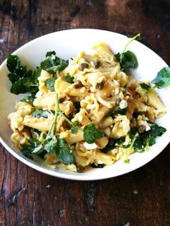 In this campanelle dish, a warm anchovy-caper-olive oil sauce dresses the pasta first; then a splash of lemon juice and reserved cooking liquid thin out the sauce ensuring it coats the pasta nicely; finally chopped hard-boiled eggs and greens complete the dish to make an impromptu, deeply satisfying dinner. // alexandracooks.com