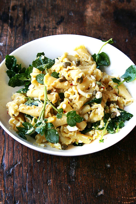 In this campanelle dish, a warm anchovy-caper-olive oil sauce dresses the pasta first; then a splash of lemon juice and reserved cooking liquid thin out the sauce ensuring it coats the pasta nicely; finally chopped hard-boiled eggs and greens complete the dish to make an impromptu, deeply satisfying dinner. // alexandracooks.com