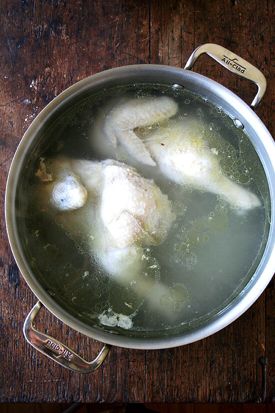 A pot with a boiled chicken in it. 