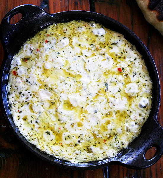 A cast iron skillet filled with baked ricotta.