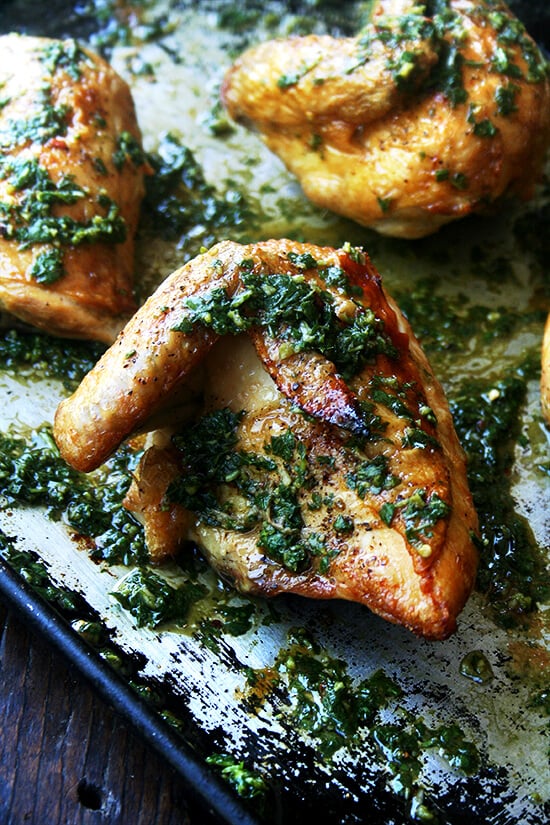 A sheet pan with crispy roasted chicken on top and an herb sauce.