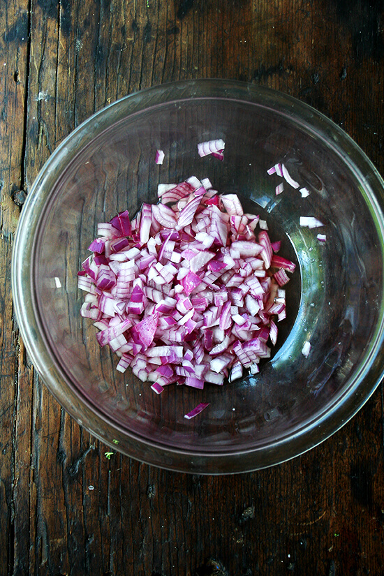 macerating red onions in a glass bowl