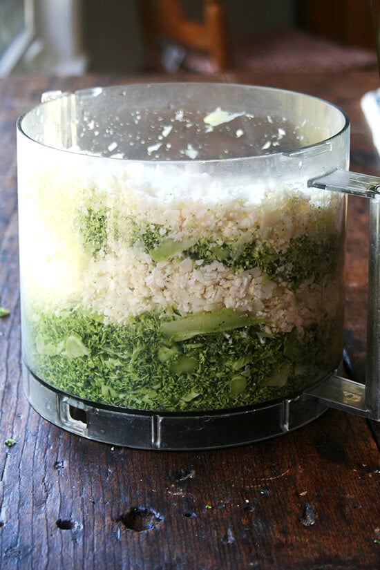 Food processor filled with shredded cauliflower and broccoli. 