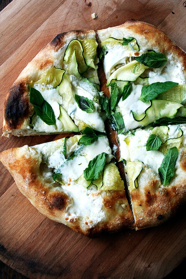 A zucchini, burrata, and anchovy pizza topped with fresh basil.