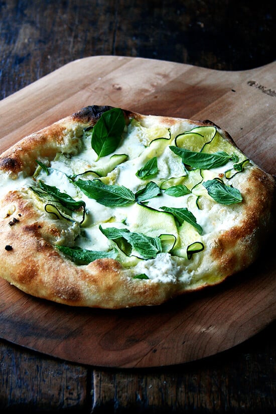 Just-baked zucchini-anchovy pizza on a pizza peel. 