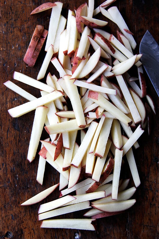 A board of cut potatoes.