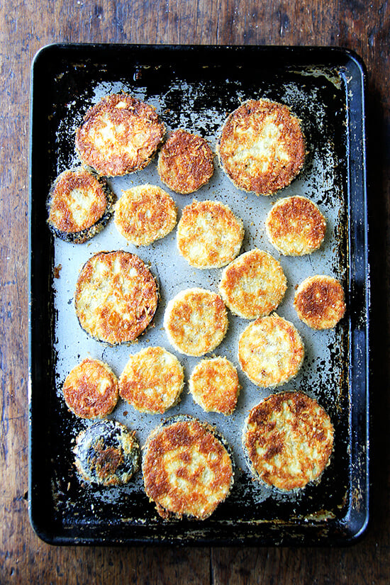 just-baked breaded eggplant rounds on a sheet pan