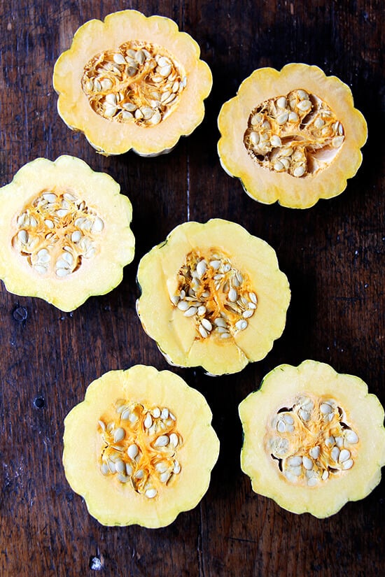 Three halved acorn squash on a table. 