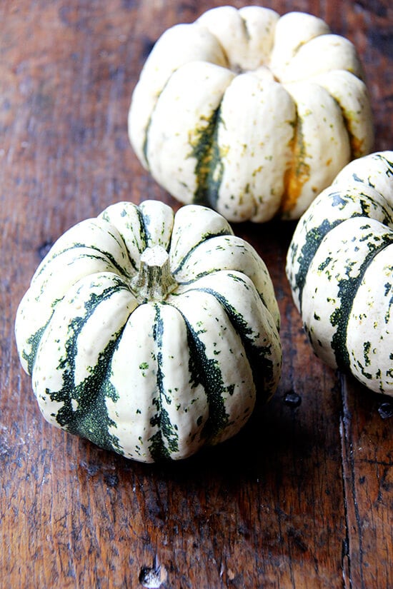 Three acorn squash on a table. 