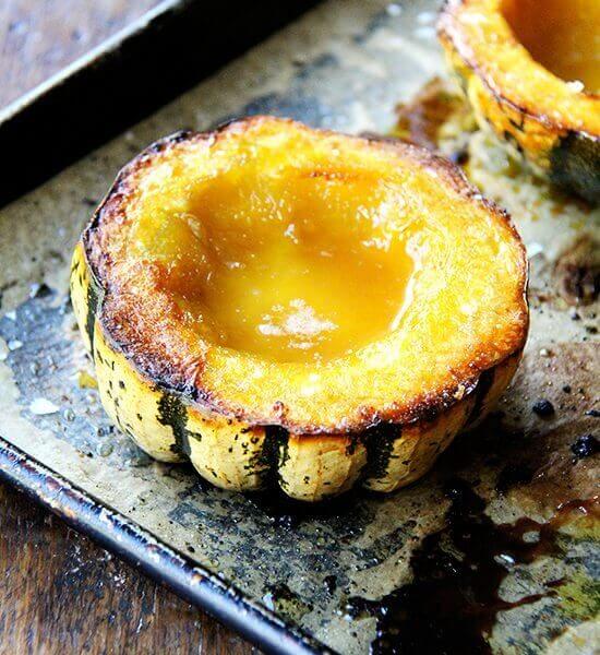 Roasted acorn squash with maple butter on a sheet pan.