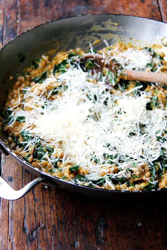 Parmigiano Reggiano added to the pan of farro risotto.