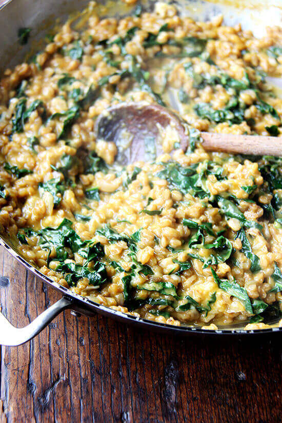 A pan of farro risotto with roasted butternut squash and kale. 