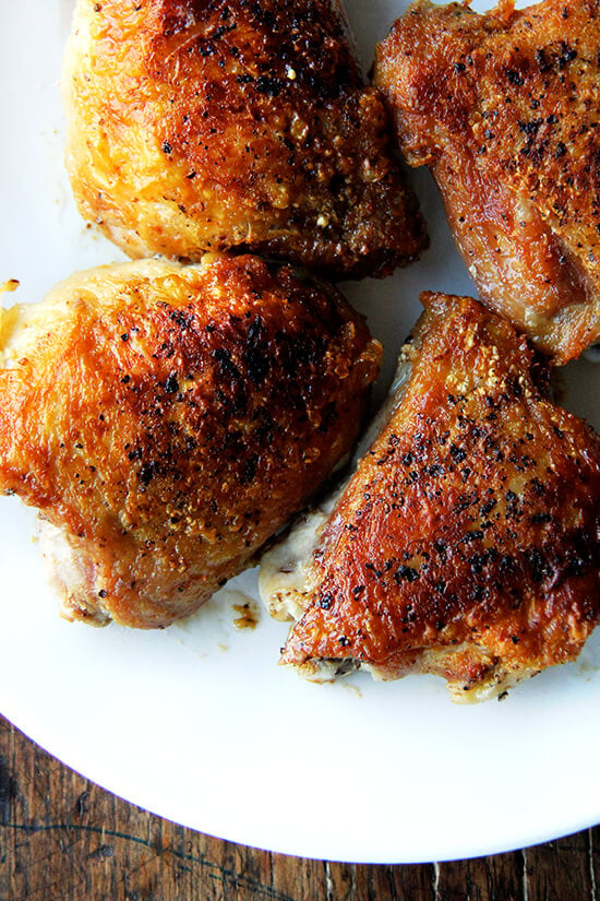 An overhead shot of crispy chicken thighs on a plate. 
