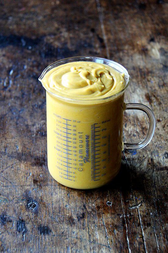 A measuring cup filled with the butternut squash pie filling.
