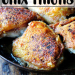 A skillet of chicken thighs with preserved lemon.