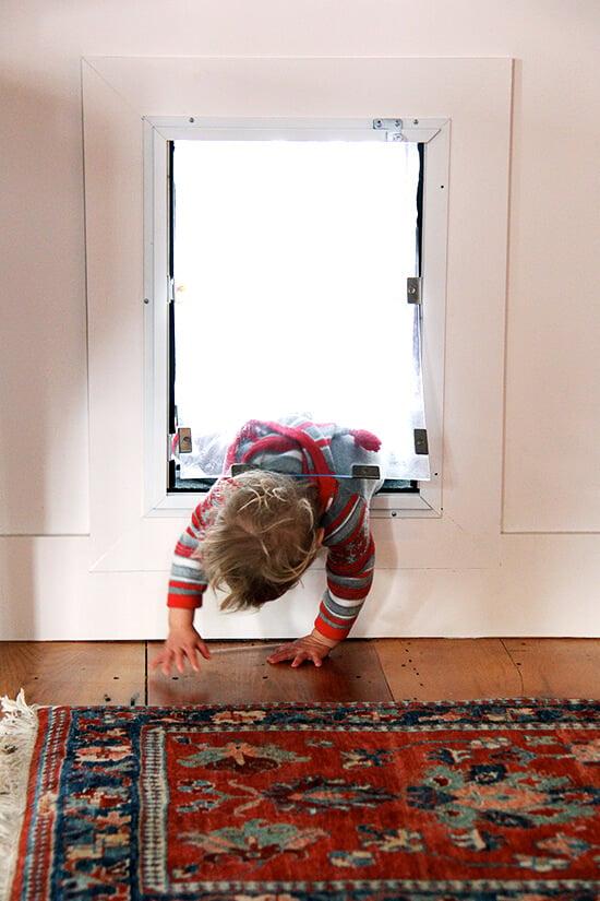 Child climbing through dog door.