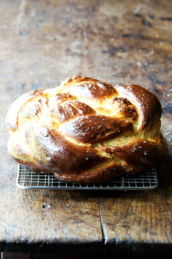 A loaf of apple cider challah bread on a cooling rack.