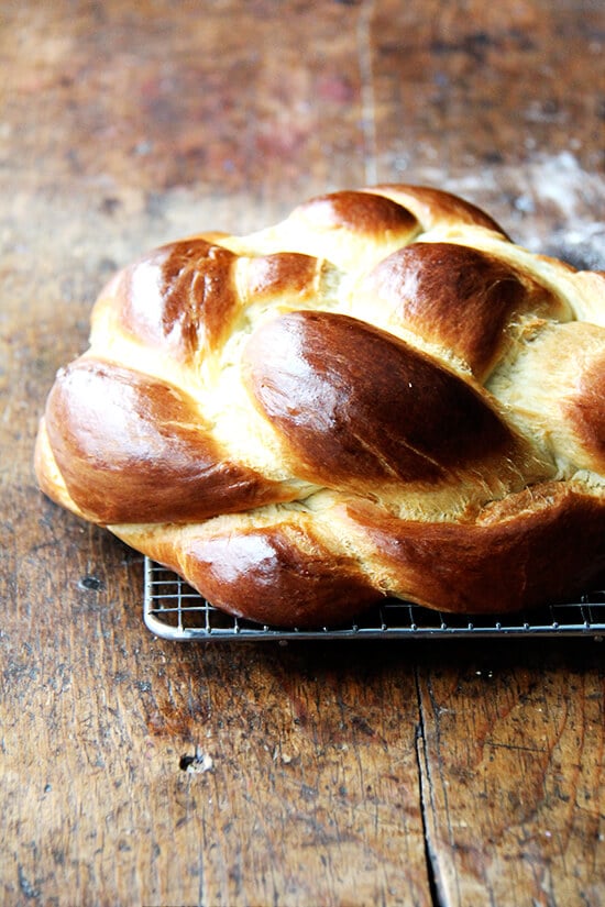 A challah bread round on a cooling rack.