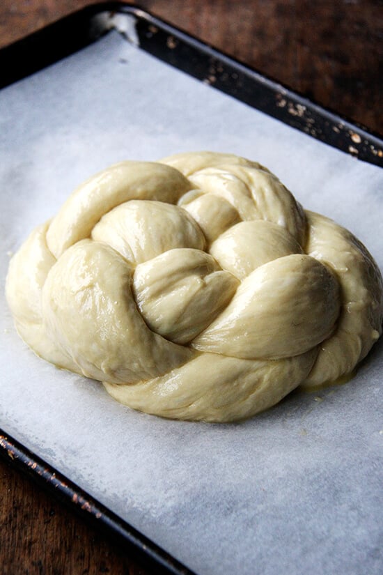 An egg-washed circle challah bread on sheet pan.