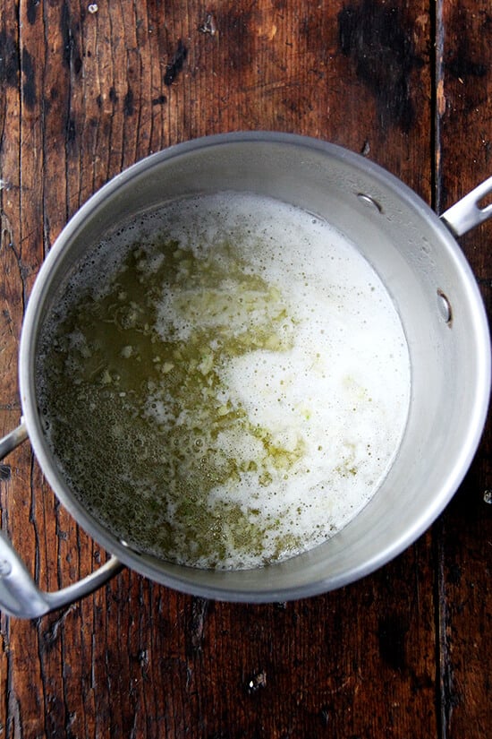 A sauce pan filled with melted butter and garlic.