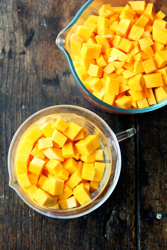 Measuring cups filled with diced butternut squash. 