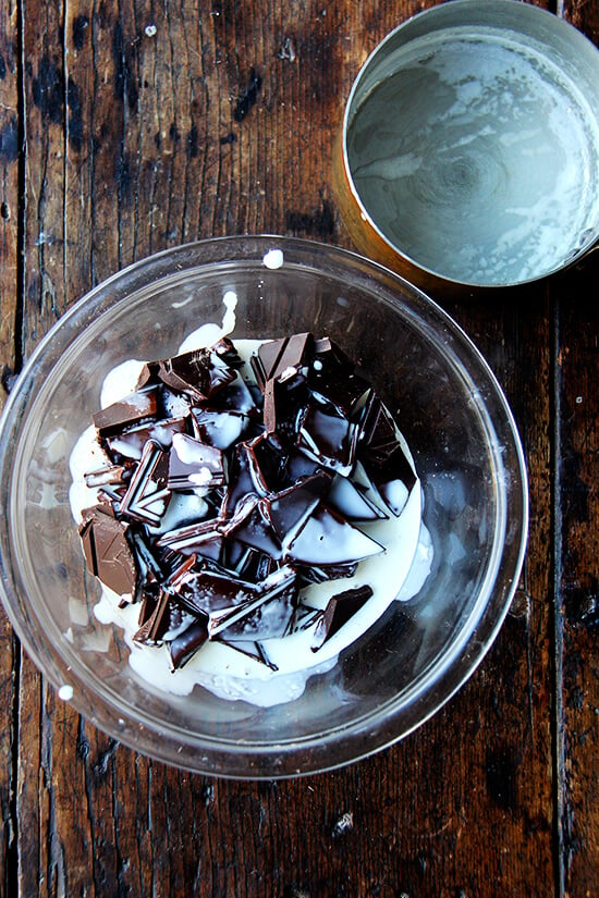 A bowl of chocolate with hot cream poured over top. 