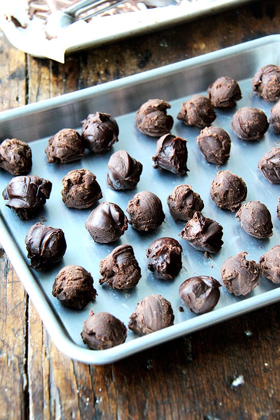 Scooped chocolate truffles on a sheet pan.