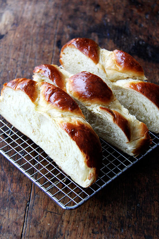 A cooling rack holding sliced day old challah bread.