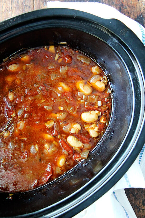 A crockpot filled with slow cooker white beans after 6 hours of cooking. 