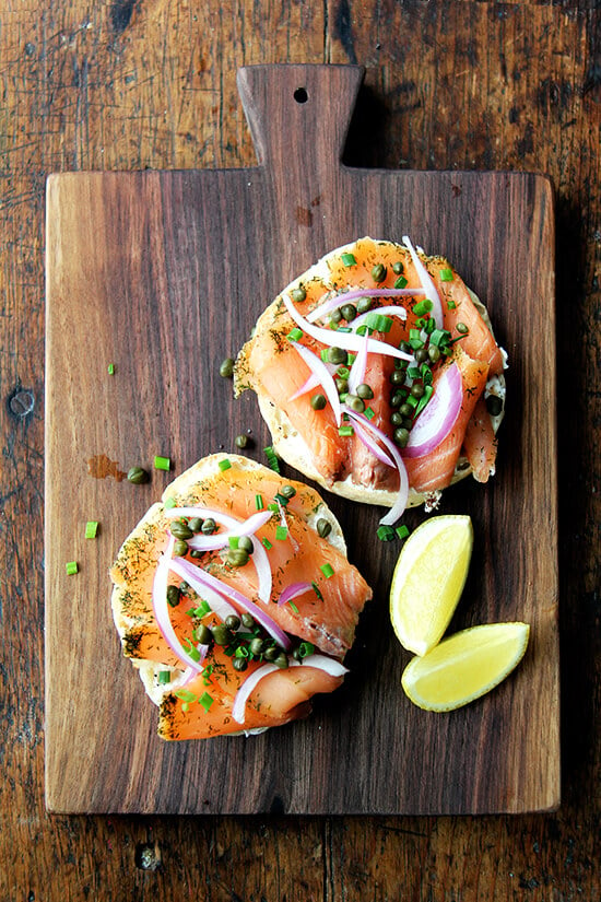 Just baked bialys on a board topped with salmon, capers, and onions. 