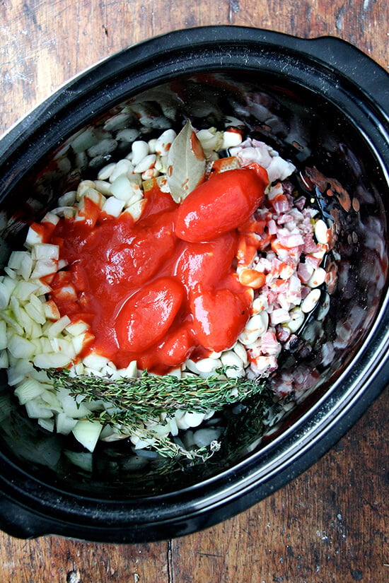 A crockpot filled with san marzano tomatoes.